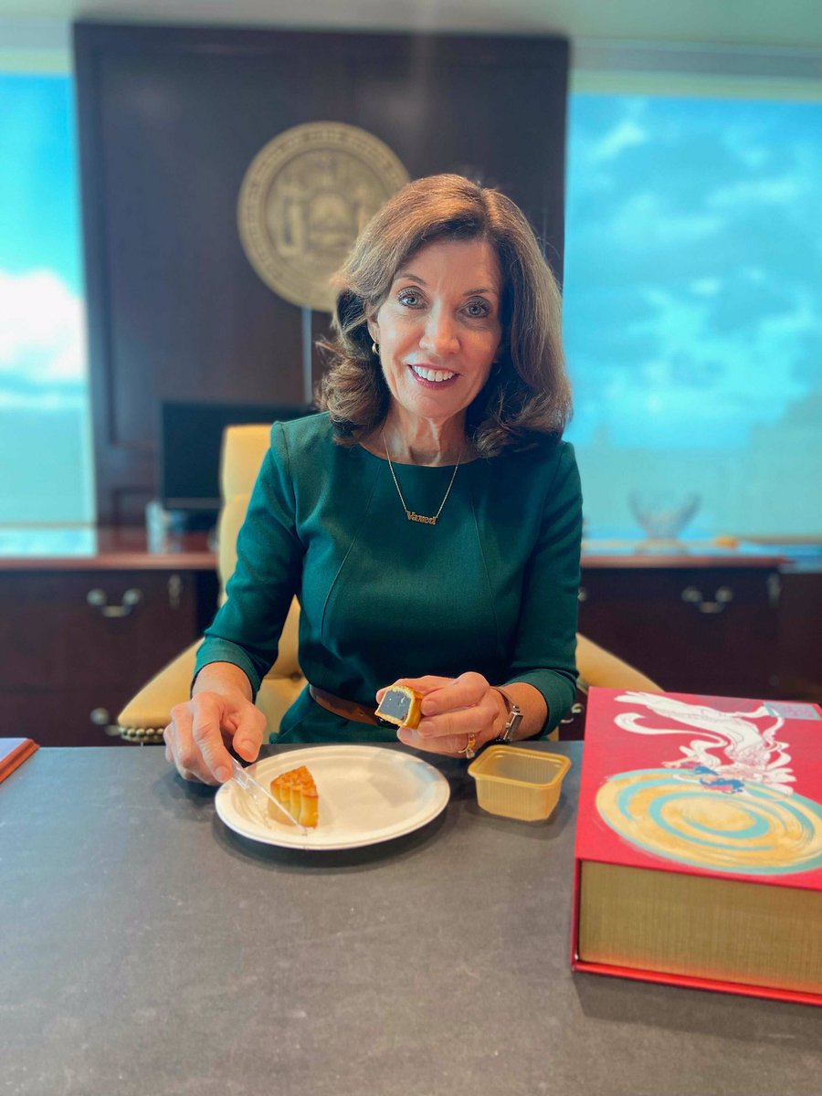 Governor Hochul sits at desk with mooncake in celebration of Mid-Autumn Festival