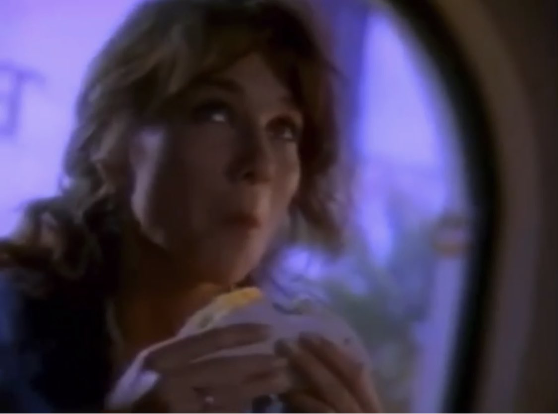rad_milk's tweet image. cursed still image from an early 90s taco bell commercial where a woman eats the taco FROM THE TOP