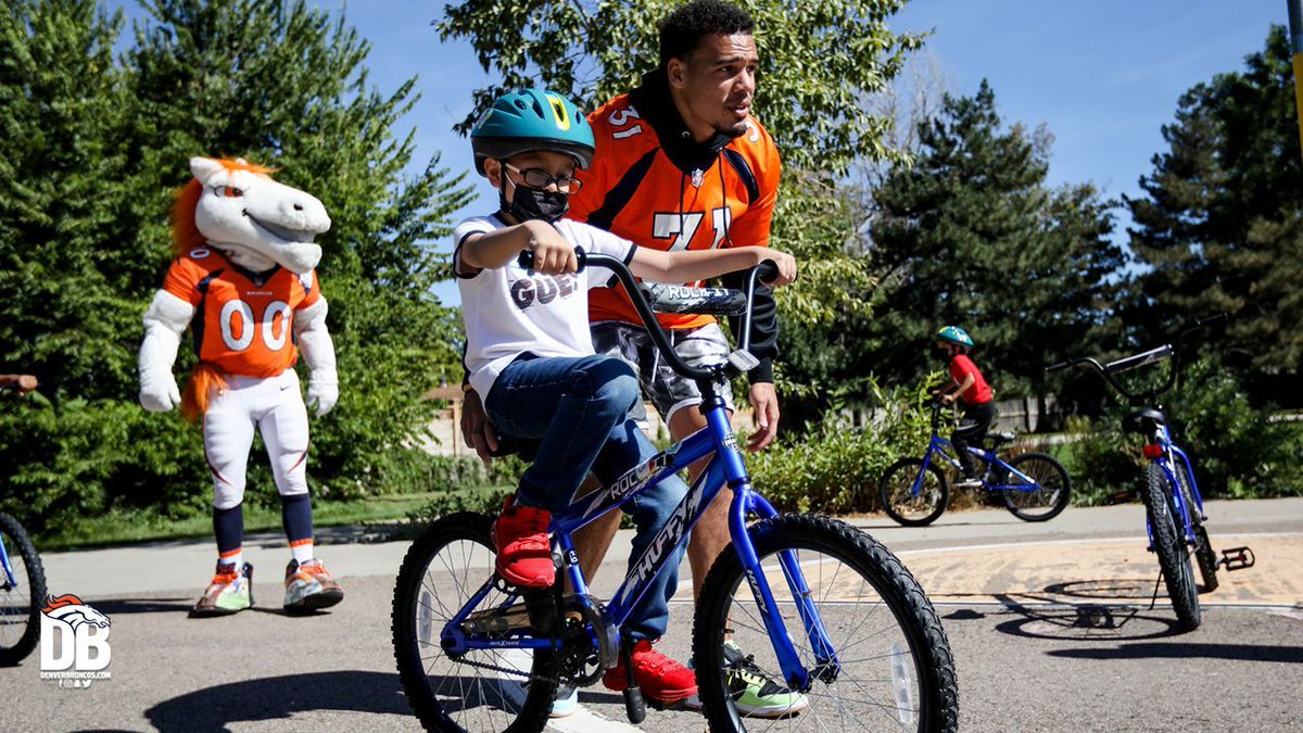Broncos's tweet photo. A few weeks ago, our football staff — led by GM George Paton &amp; Coach Fangio — put together bikes for under-resourced elementary kids in honor of Greg Knapp.

Today, those kids received their bikes from Broncos players, @BroncosCheer &amp; @5280Miles. 🧡

📸's: https://t.co/tPT2rsZ9q5 https://t.co/g0MN0Z28M6