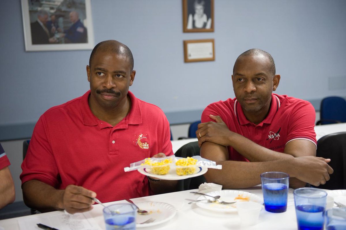 STS-129 Mission Specialist Robert Satcher (right) joins fellow crewmate Leland Melvin for a preflight food tasting session at the Johnson Space Center in May 2009.