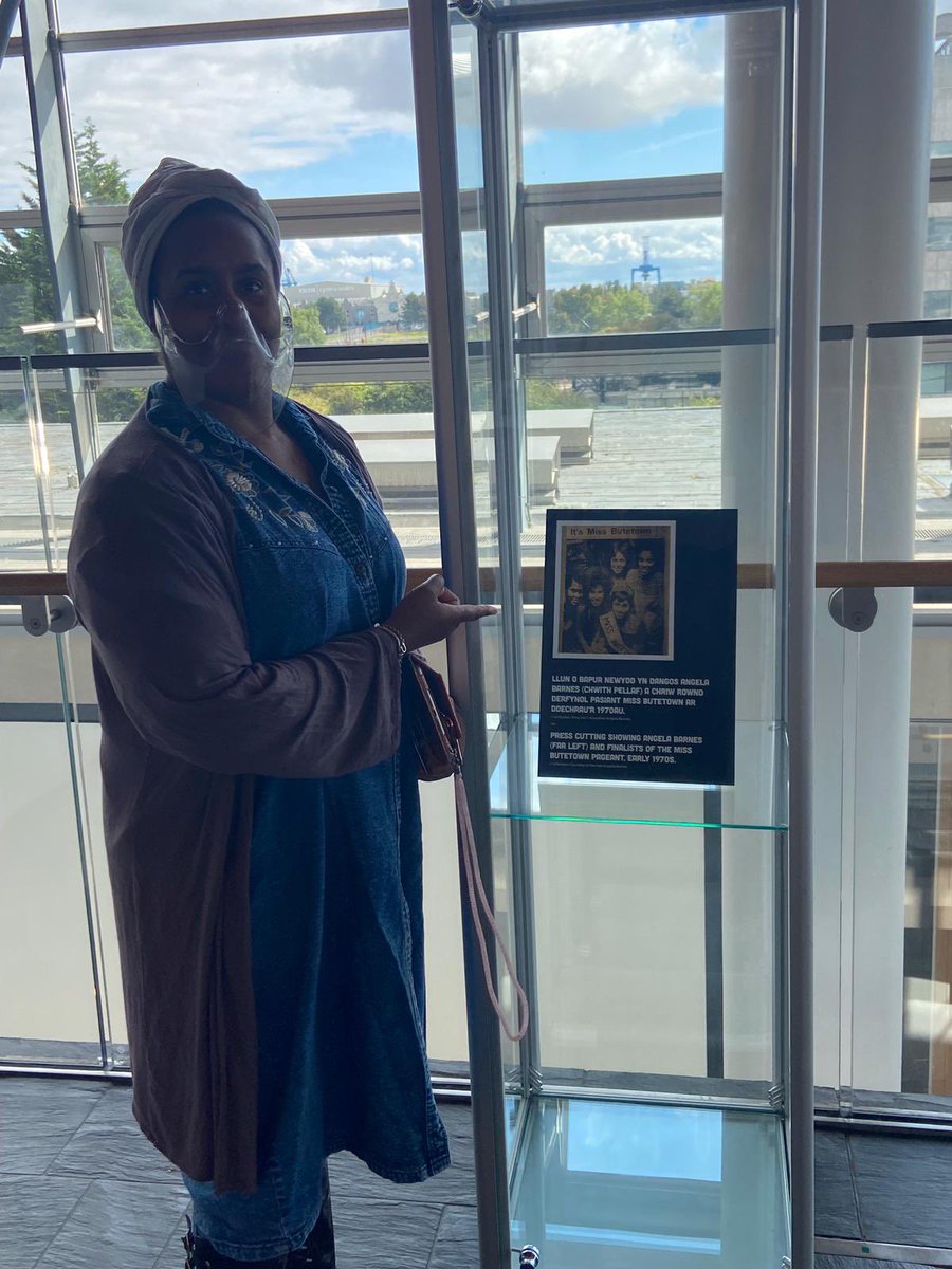 RCCymruWindrush's tweet photo. Annika Nation-Reid views our exhibition at the Senedd @YPierhead to pay tribute &amp; honour the legacy of her late mother and Vice Chair of Windrush Cymru Elders in Wales - Mrs Angela Barnes RIP fondly known as "Mama Barnes" who gave of her very best to sustain @BHCymru365 @BHMWales https://t.co/NseTiDx9nL