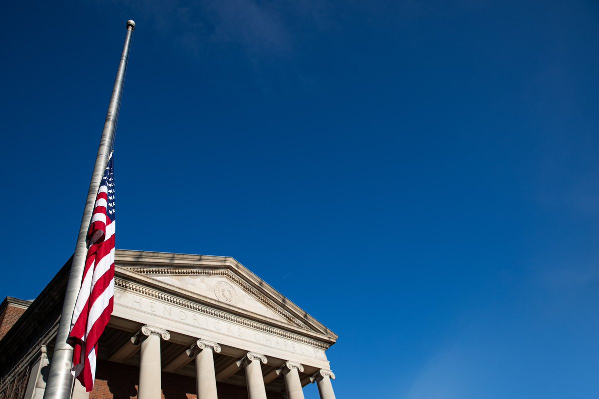 Flag sits at half mast against Hendricks Chapel with a blue sky background