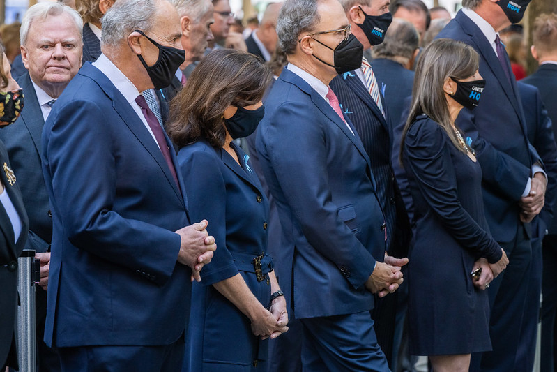 Governor Hochul stands with others with her head bowed down