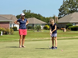 GlenLakes Jr. Leaguer, Andrea Bull, sinks putt while GlenLakes member, Lynn Bull watches on.