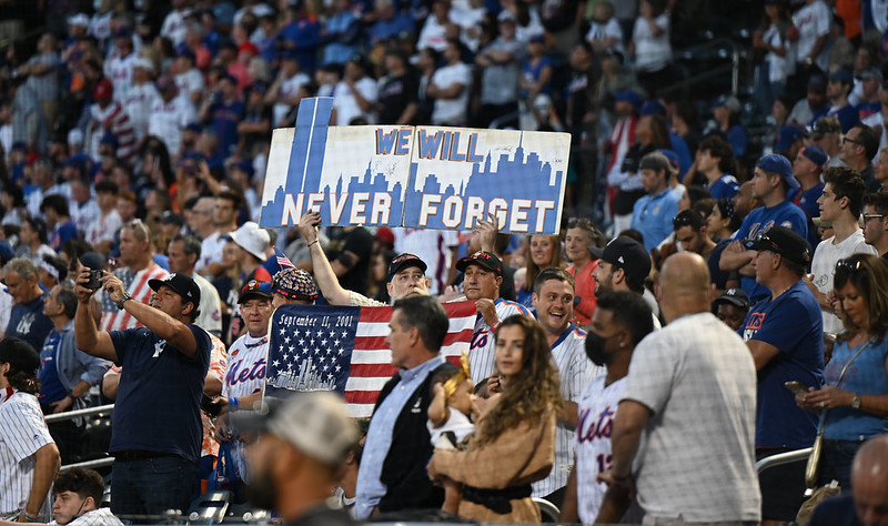 Crowd holds sign that reads "We will never forget"