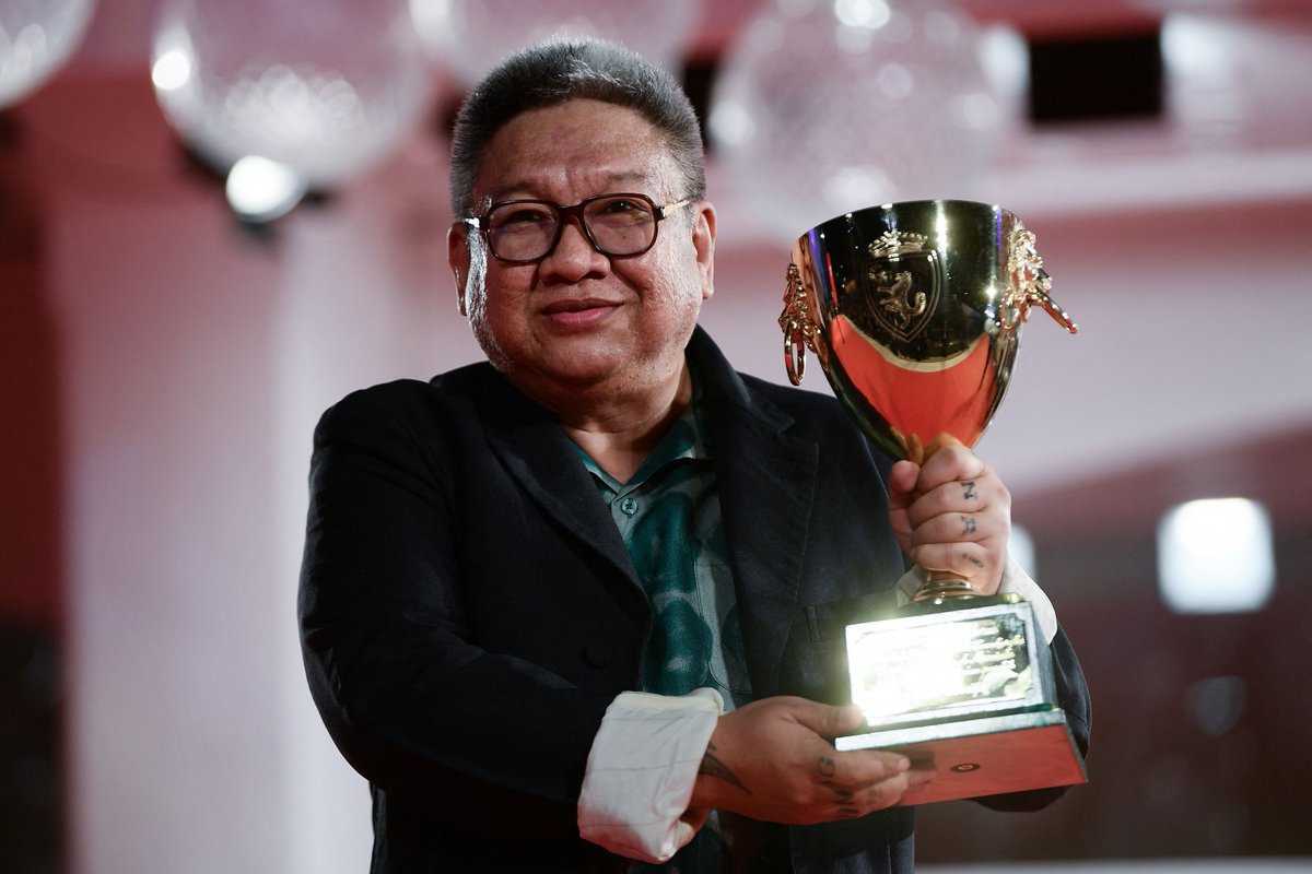 Filipino director Erik Matti poses with the trophy he received on behalf of...