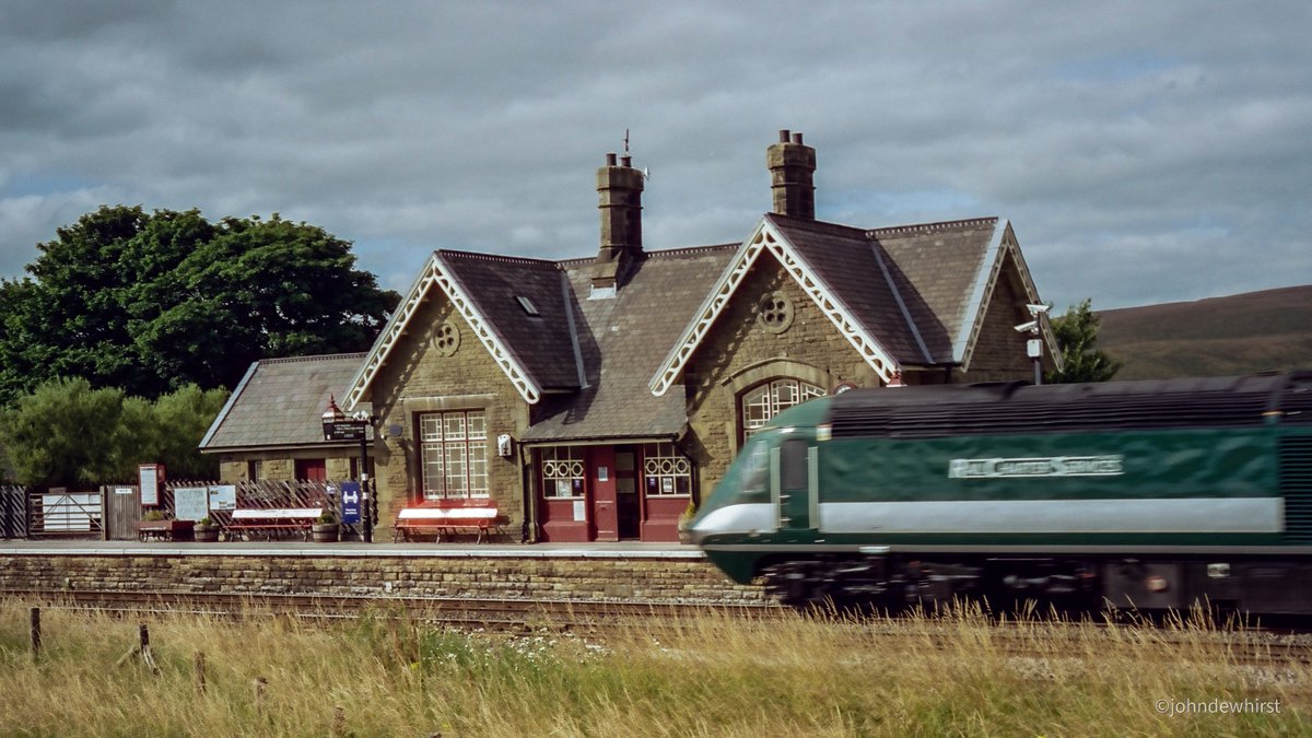 jpdewhirst's tweet photo. High Speed Train on the Settle & Carlisle Railway heading southwards, #StaycationExpress passing Ribblehead Station. Whernside in the background. @CharterRail #filmphotography @setcarrailway @foscl https://t.co/y5y9GWjvJR