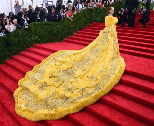 MetroUK's tweet photo. If we're talking Met Gala fashion we HAVE to talk about @rihanna 👑

This yellow @guopeiofficial gown took more than two years to create, weighed 25kg and it's 16 foot train ensured Riri took over the Met Gala steps. https://t.co/Vy1ySaho7K