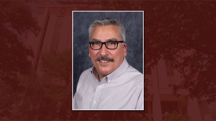 De Miranda headshot on maroon background