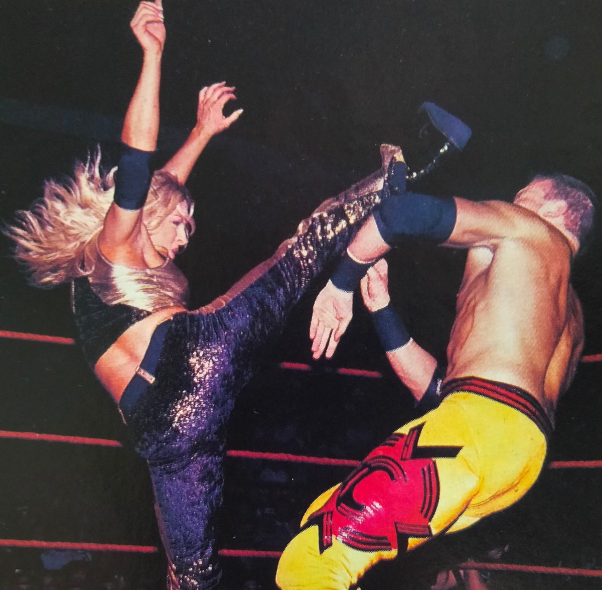 Trish Stratus gets in a high kick on Christian during the 