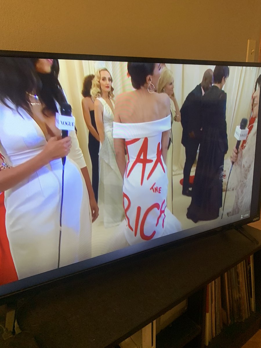 AOC wearing a Tax the Rich dress at the #MetGala with Kris Jenner over her shoulder wow icon