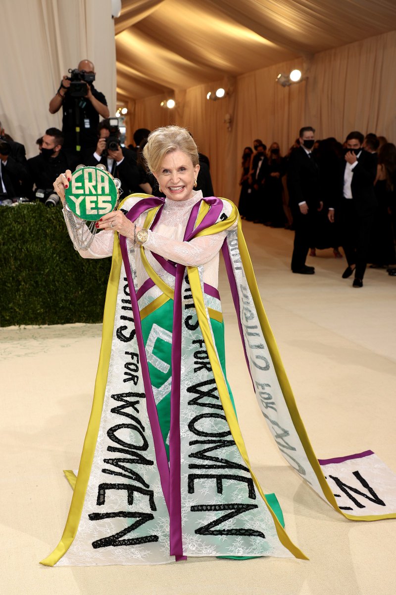 voguemagazine's tweet photo. Congresswoman @RepMaloney of New York’s 12th district is at the 2021 #MetGala, wearing a gown in suffragist colors complete with a cape embroidered with the phrase “Equal Rights for Women” and white ‘ERA’ letters down the front of the dress https://t.co/74CnDV6qNG https://t.co/Rd7R7thMFb