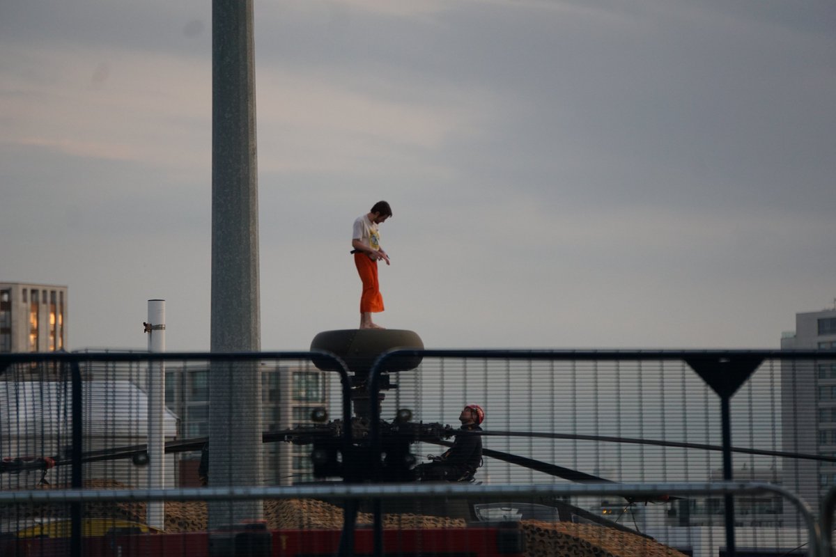 #StopDSEI activist scales the fence of the Excel centre on Monday evening and occupies the top of an 'Apache attack helicopter'