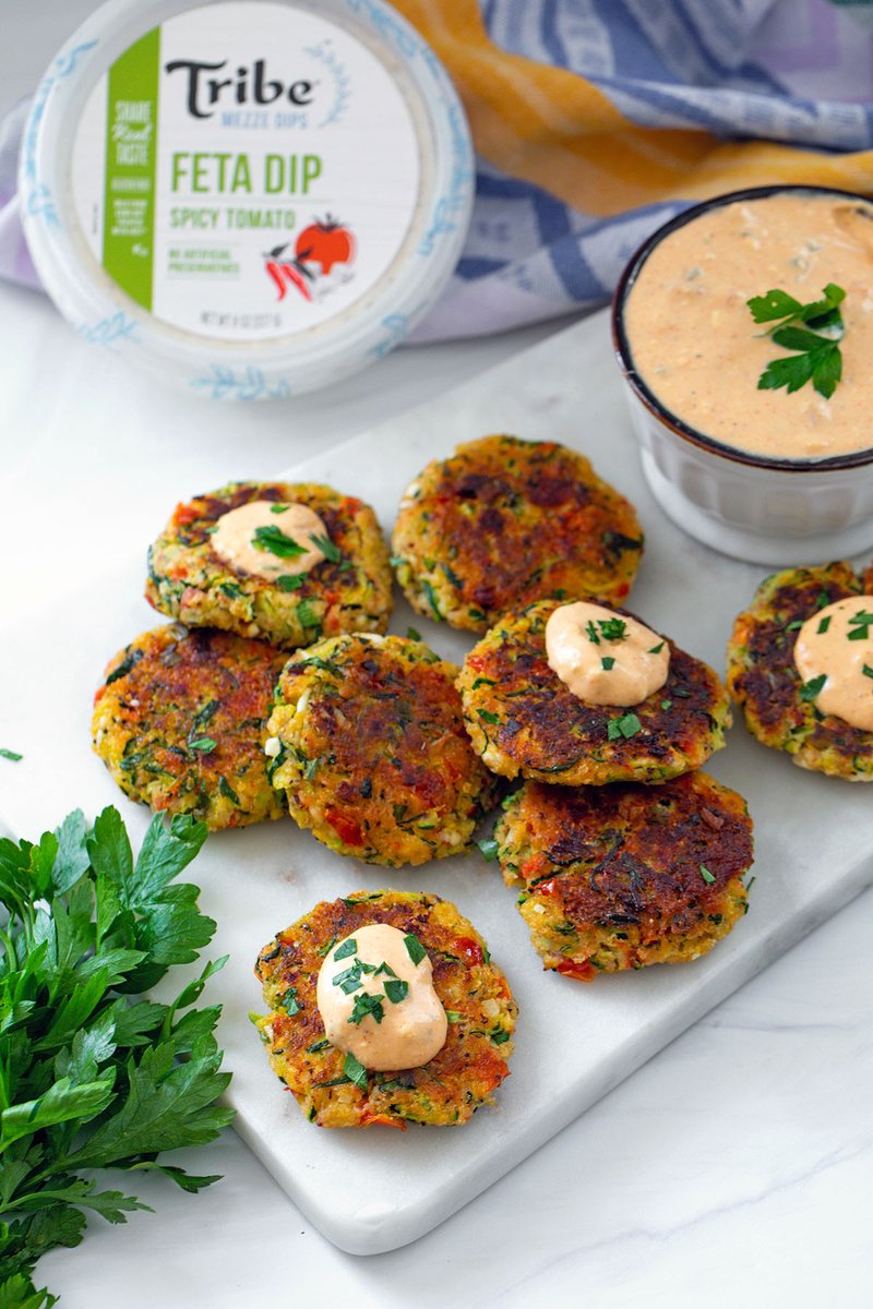 I topped these easy-to-make Greek Zucchini Cakes with <a href="/TribeHummus/">Tribe Hummus</a>'s new Spicy Tomato Feta Dip… But any of the varieties from their new Mezze Dip line would be delicious! 😋 {sponsored} Recipe → wearenotmartha.com/greek-zucchini…
