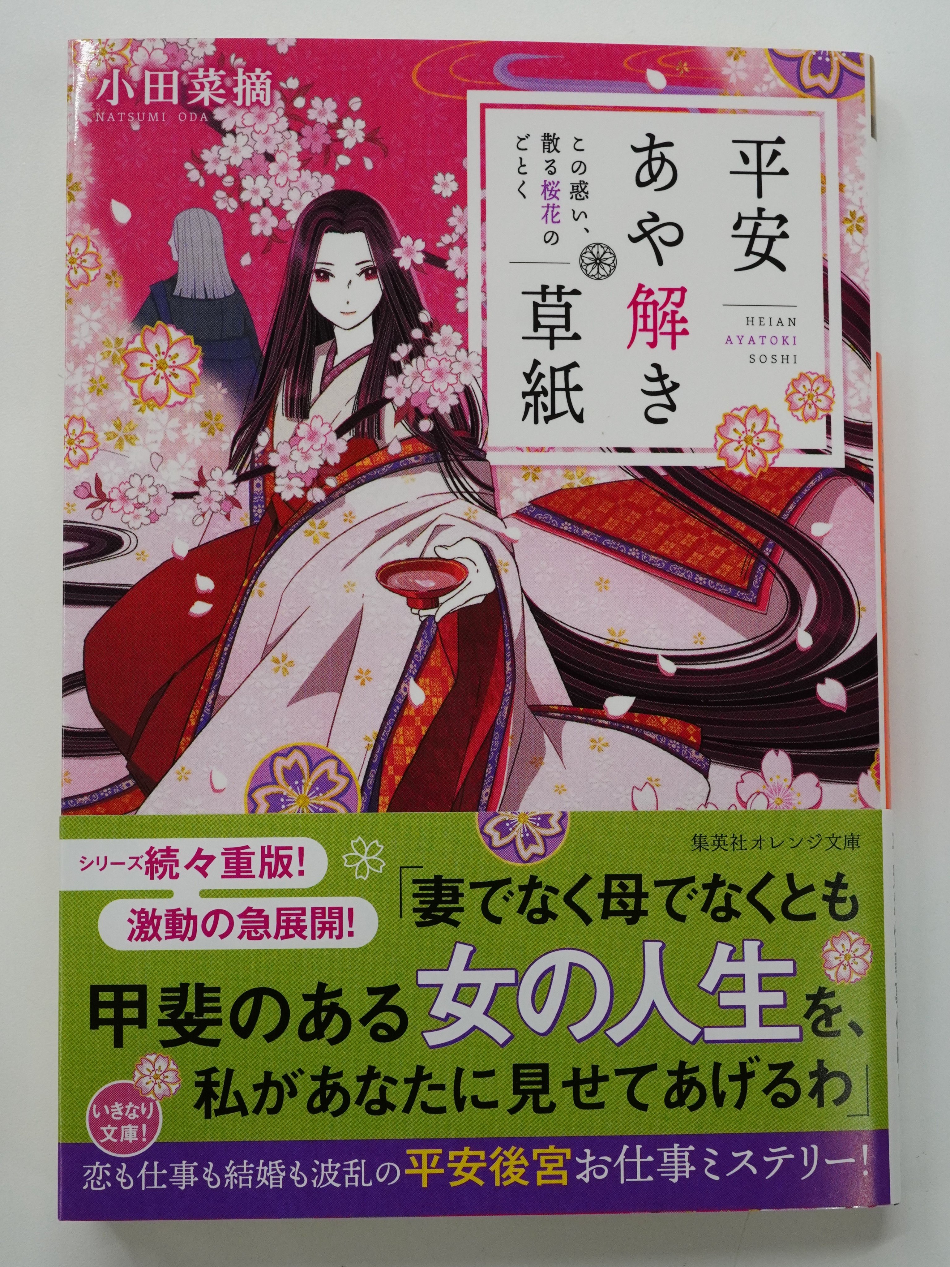 オレンジ文庫 集英社 好評発売中 小田菜摘 平安あや解き草紙 この惑い 散る桜花のごとく 装画 シライシユウコ 藤壺女御の男児出産をきっかけに 女たちの争いが激しくなった 同時に嵩那の東宮擁立を求める声も高まり 伊子は頭を抱える