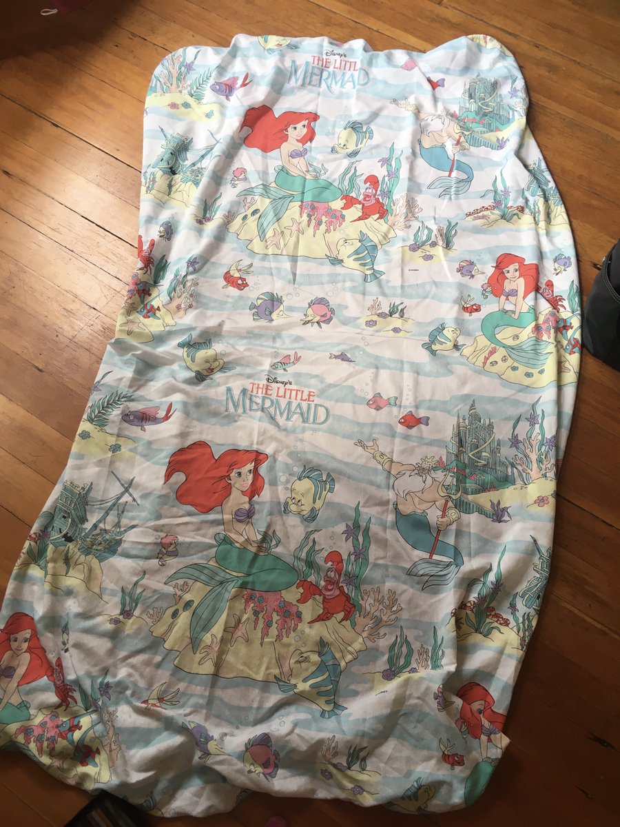 Bedsheet of The Little Mermaid laid out on the floor