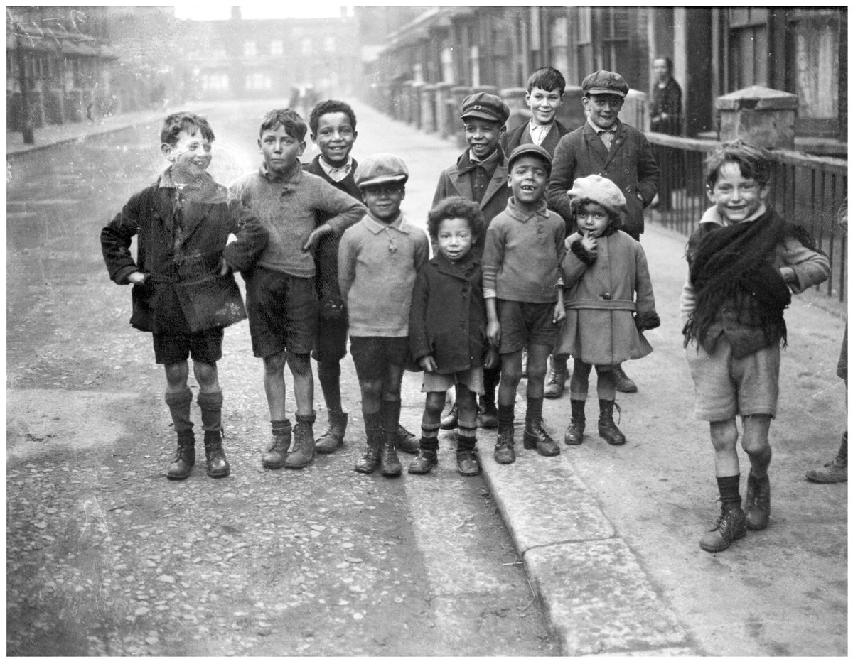 "A group of working class children, black and white, playing together on 'Crown Street' in Canning Town, London, E16. "
1930s.
Unattributed photograph for Barnaby's Studios Ltd.
© Mary Evans Picture Library
