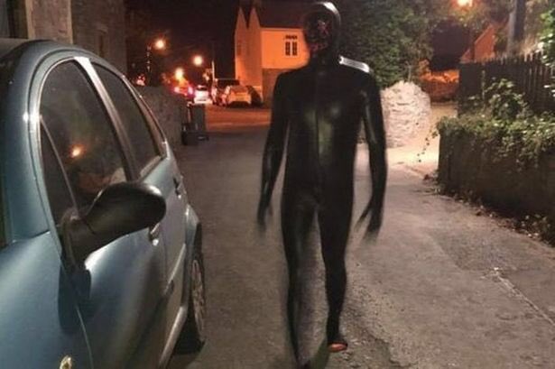 Um homem nu, apenas usando uma máscara de látex preta, é visto em estradas e locais abandonados. Ele encara as pessoas, fica imitando um porco e após isso se esconde.
