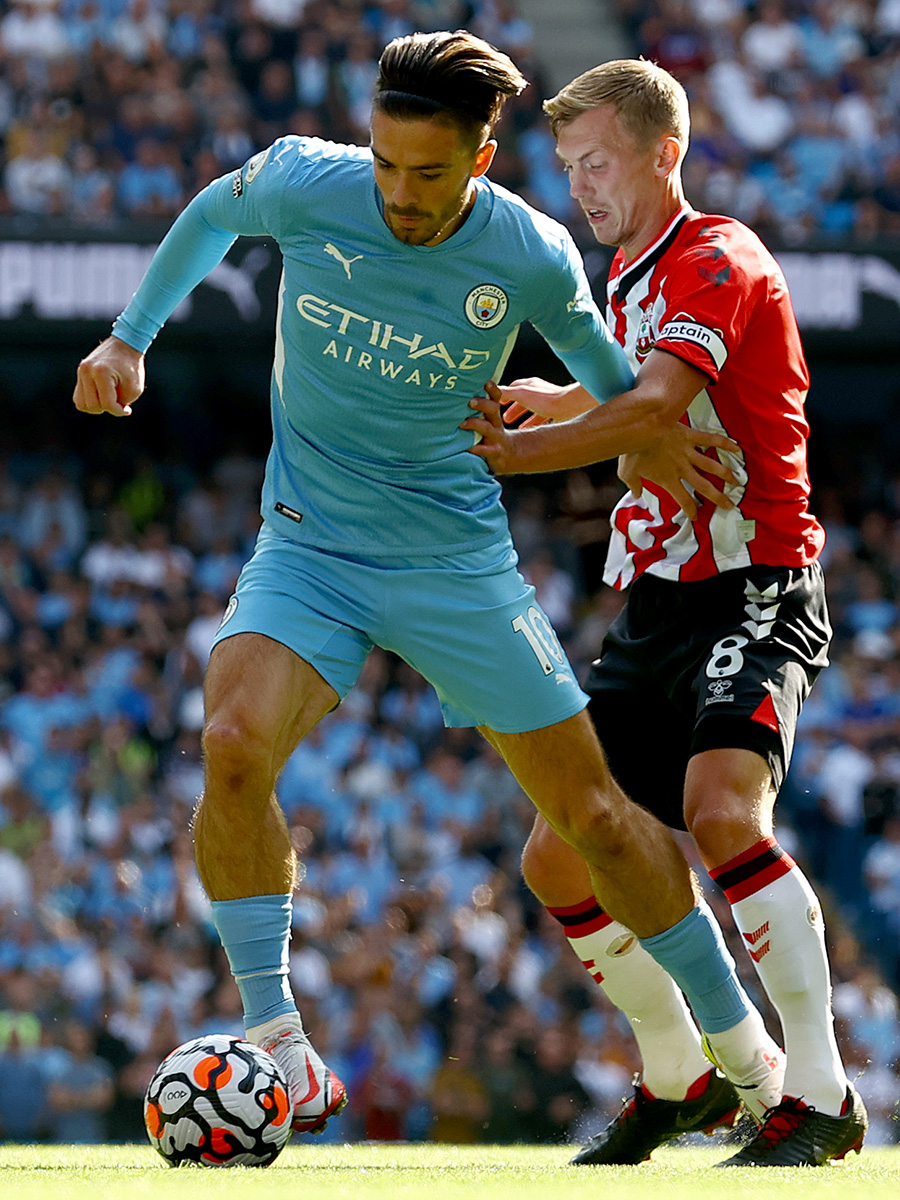 James Ward-Prowse puts pressure on Jack Grealish, with the Manchester City player trying to hold off the Southampton captain while in possession of the ball.