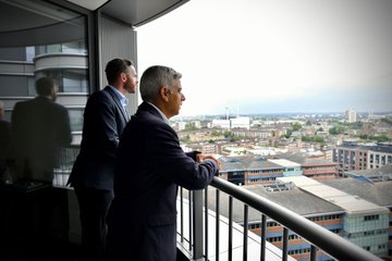 The Mayor of London looking at the skyline from a balcony in one of the newly opened flats. 