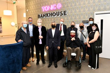 Mayor of London stood in front of the Tonic Bankside sign in a communal area with a group of invited guests. 