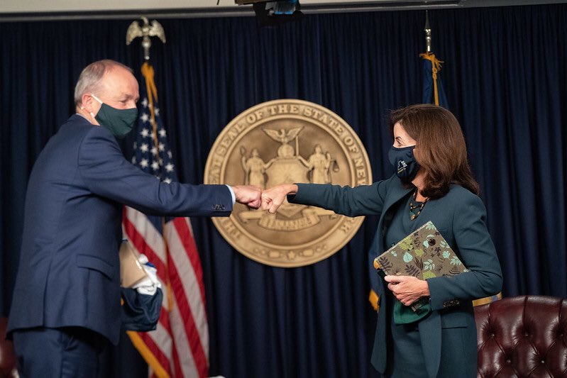 Governor Hochul (right) fist bumps Taoiseach Micheál Martin of Ireland (left) both masked.