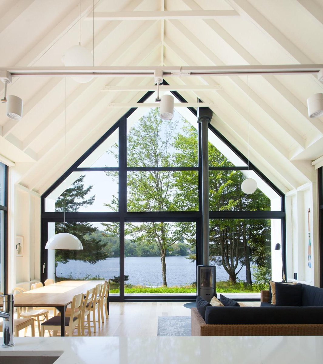 Great room with double-height ceiling opening up to views of Lac Plaisant, Saint-Élie-de-Caxton, Canada by YH2  #interiors #architecture