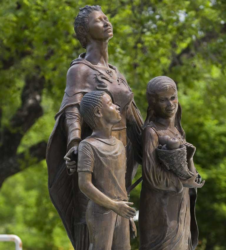 Statue of an African American woman with a girl and a boy, poised as if stepping into freedom. Artist: Eddie Dixon