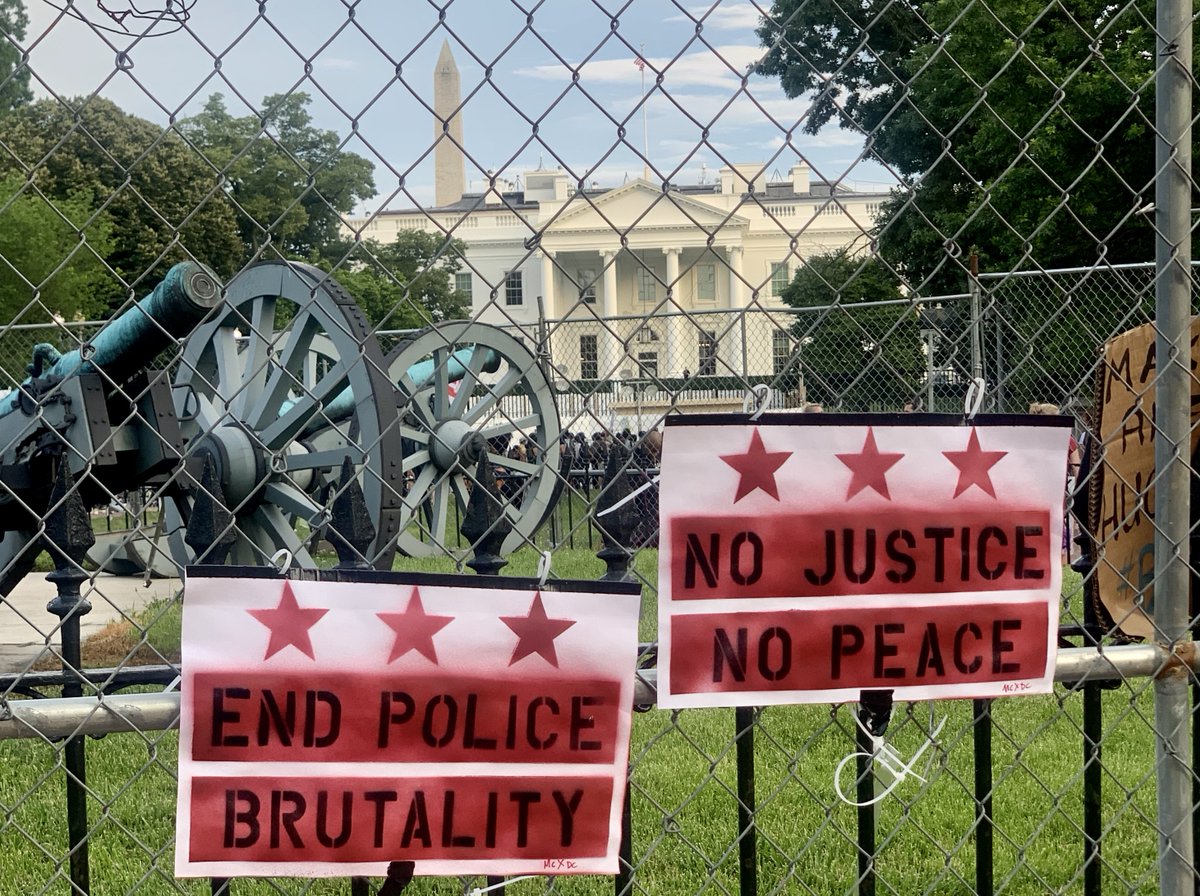 A photo from outside the White House, where two protest signs say "end police brutality" and "no justice no peace."