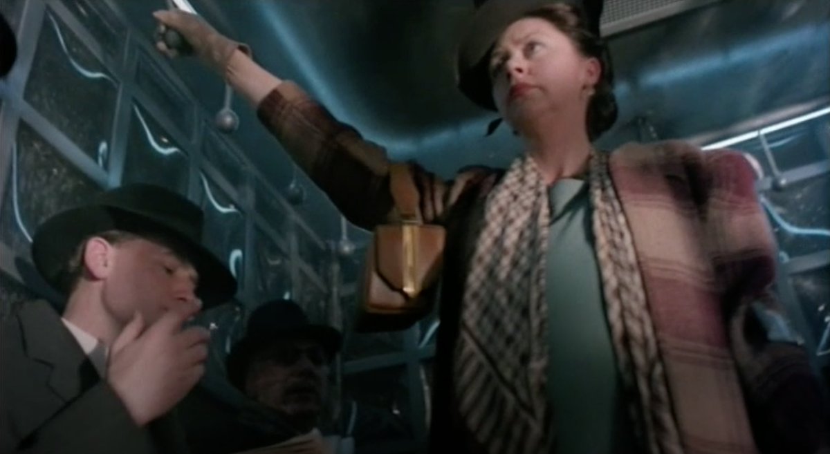 Meanwhile (although the camera never cuts back far enough to make this too obvious, but it's obvious): the tram car contains eight man, including Sam, all sitting, none of them standing to give their seat to the strap-hanging woman with one leg (obviously a bombing victim.)