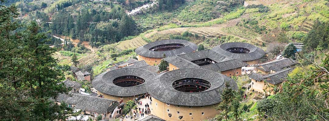 In South China's Fujian province, Tulou (earth/mud building) architecture was followed by the Hakka people. They accommodated families of several generations like mini villages. They were closed outside and open inside.They came in symmetric shapes like round, oval and square.