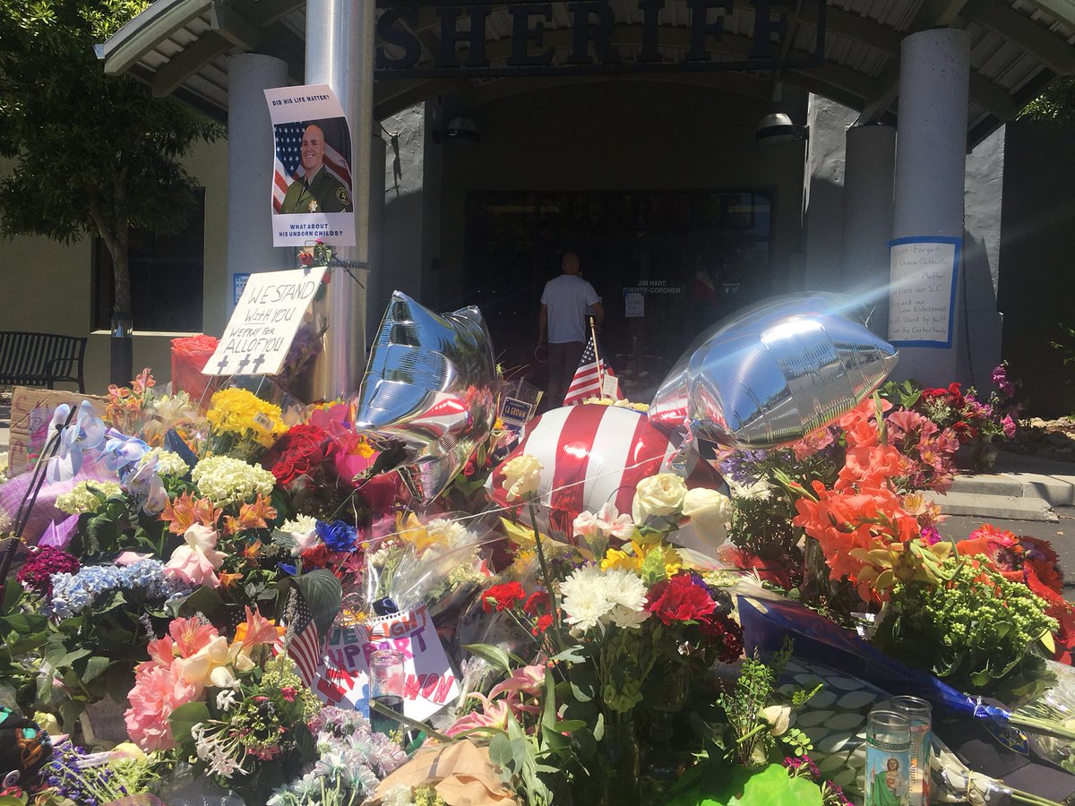 RFladeboe7's tweet photo. Memorial is growing in honor of slain #SantaCruzCo #DeputyDamonGutzwiller. Sheriff Jim Hart expected to provide new info (2 pm presser)about alleged ambush that led to Gutzwiller’s death. FBI is here looking at suspect #StevenCarrillo in connection with May 29 killing in Oakland https://t.co/T83Lu4iyRS