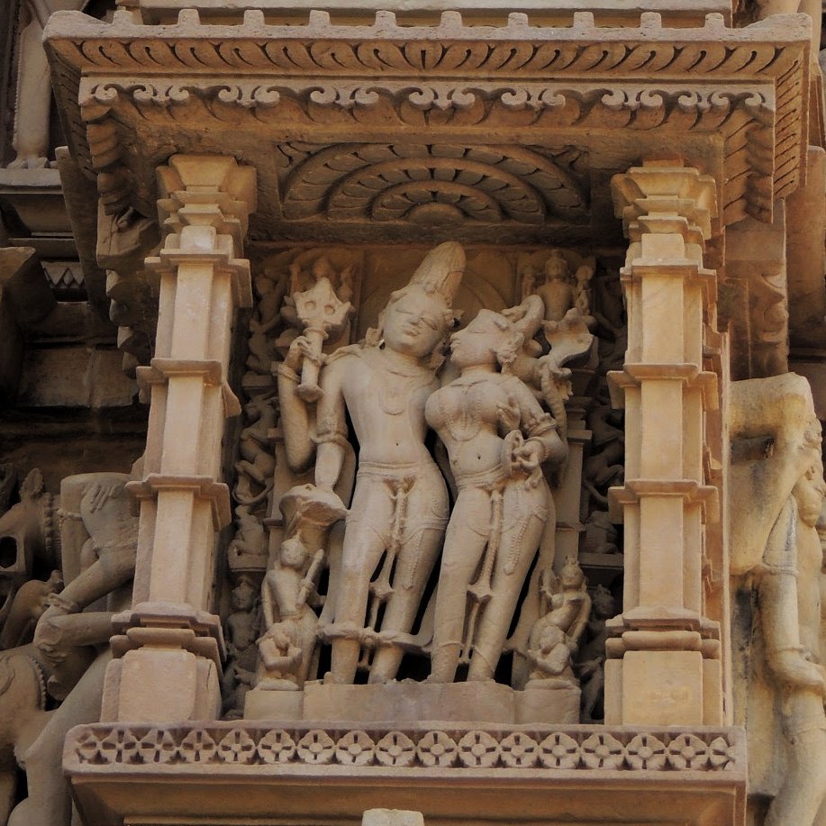 उ is for उमा-महेश्वरा. Pic 6. Shiva and Parvati are accompanied by attendants and devotees. Parvati holds a mirror in her hand. (Khajuraho, 10th century CE)