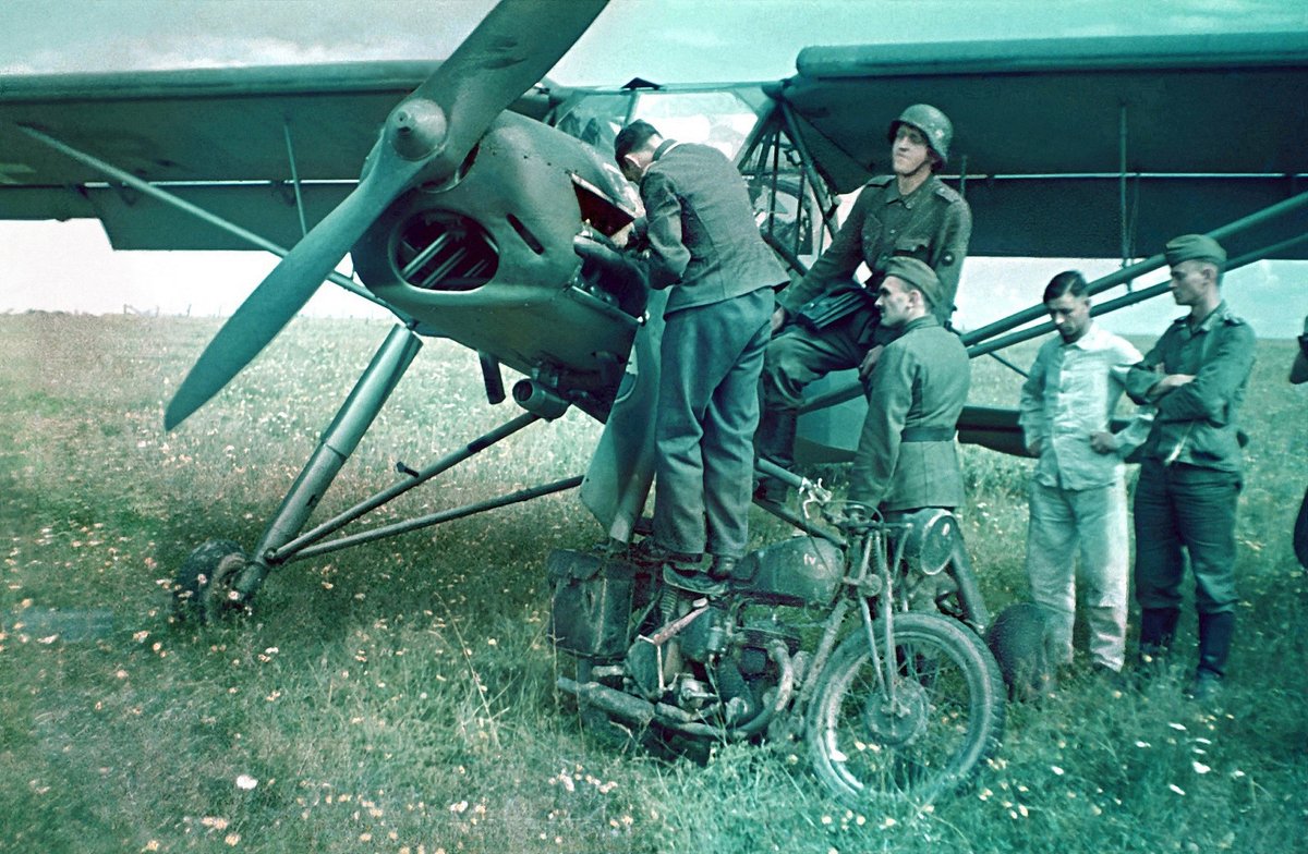 clark_aviation's tweet photo. France, June 1940.  A Luftwaffe mechanic repairing a Fieseler Fi 156 Storch observation aircraft, that made an emergency landing in a field. The mechanic is standing on an ex-British Army BSA M20 motorcycle, presumably left by retreating members of the BEF, en-route to Dunkirk. https://t.co/QEvzGloAfT