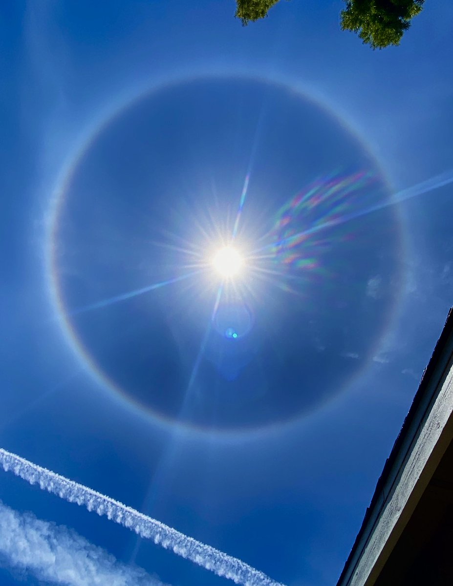 acmishra's tweet image. A quick iPhone photo I took of a halo around the Sun this afternoon.  The halo had distinct rainbow like colors, though not easy to see in the photo, as light from the Sun interacted with ice crystals high in the atmosphere.  Very cool to see.
#Sun #SolarHalo