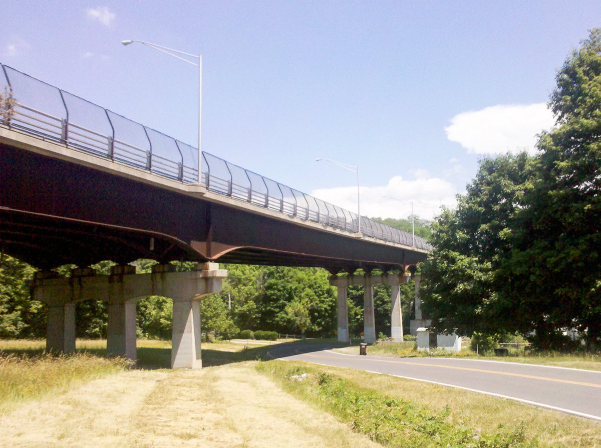 Finally we're at the bottom, beneath the big highway bridge. Traffic rushes by above us. I'm sweating, it's hot out.