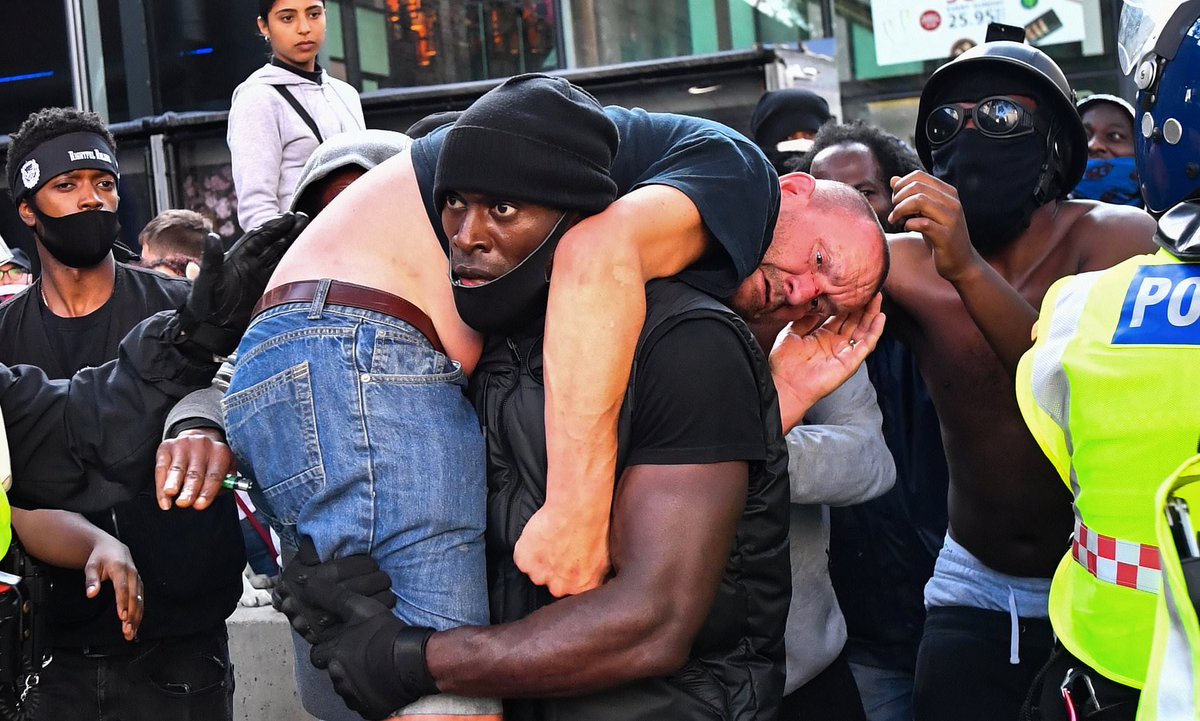 Incredible photo: a #BlackLivesMatter protestor carries an injured far-right counter-protestor to safety in London. Amid all the ugliness, a beautiful moment of humanity. 📷 by Dylan Martinez ⁦@Reuters⁩