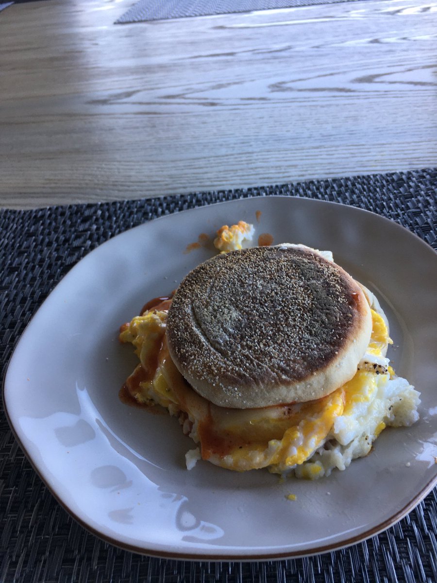 Two fried eggs, w provolone and hot sauce on a slightly burnt English