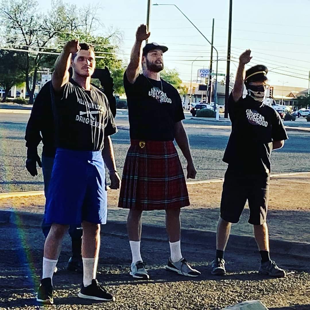 Three neo-Nazis throw up salutes while another appears to film the action.