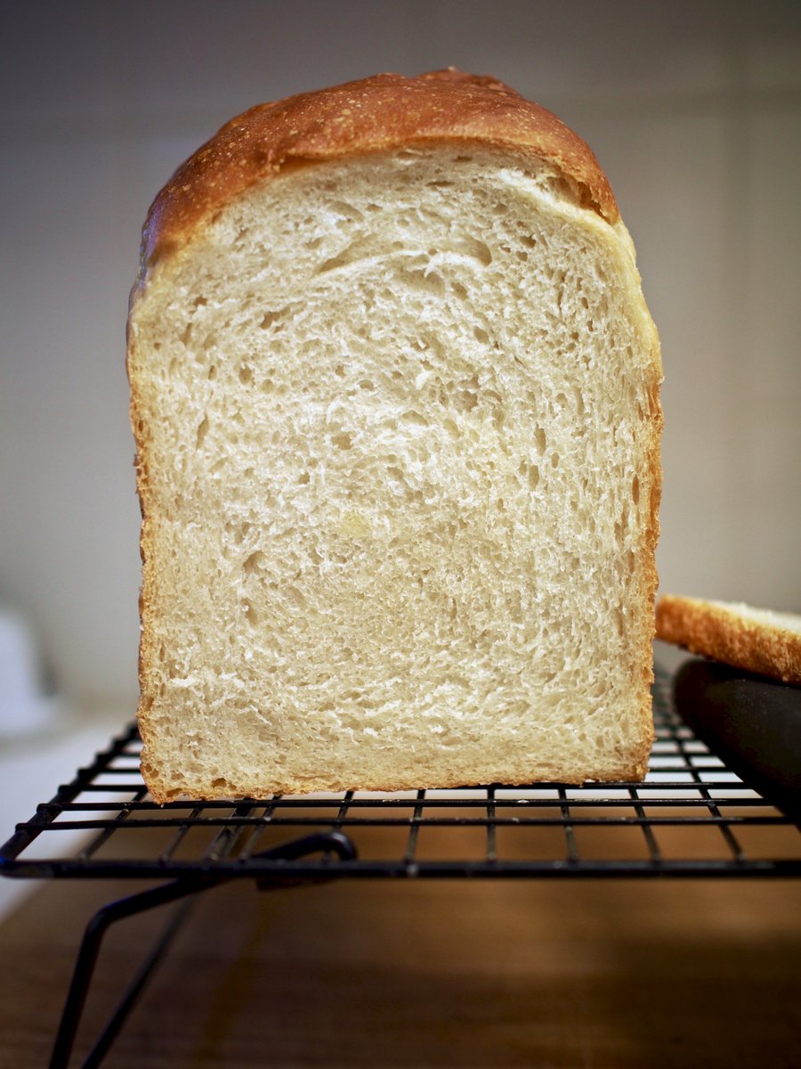 Direct shot of the crumb of the sliced loaf. You can see the curvature of the forming and the fairly tight (but not tense) structure. A few holes near the top, but this bread would readily take butter without any drips. Powerful sandwich-making material.