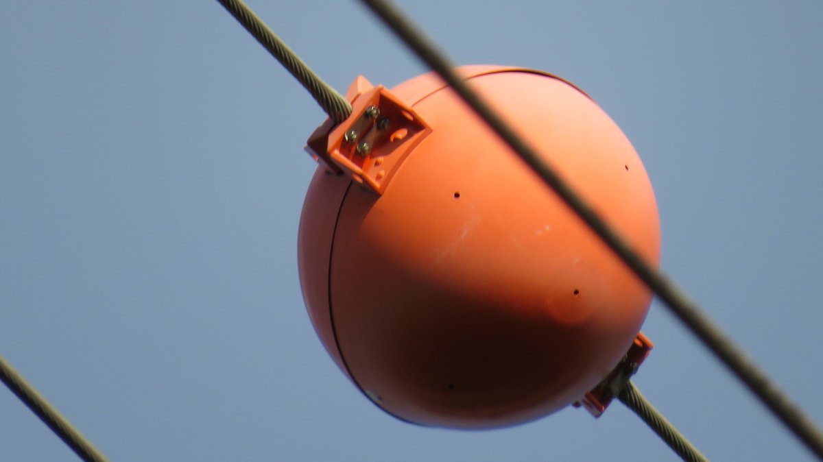 undoubtedfacts's tweet photo. No, you're not seeing things. Those "marker balls" on electric wires are there for a good reason. https://t.co/t2bbP3VWW8