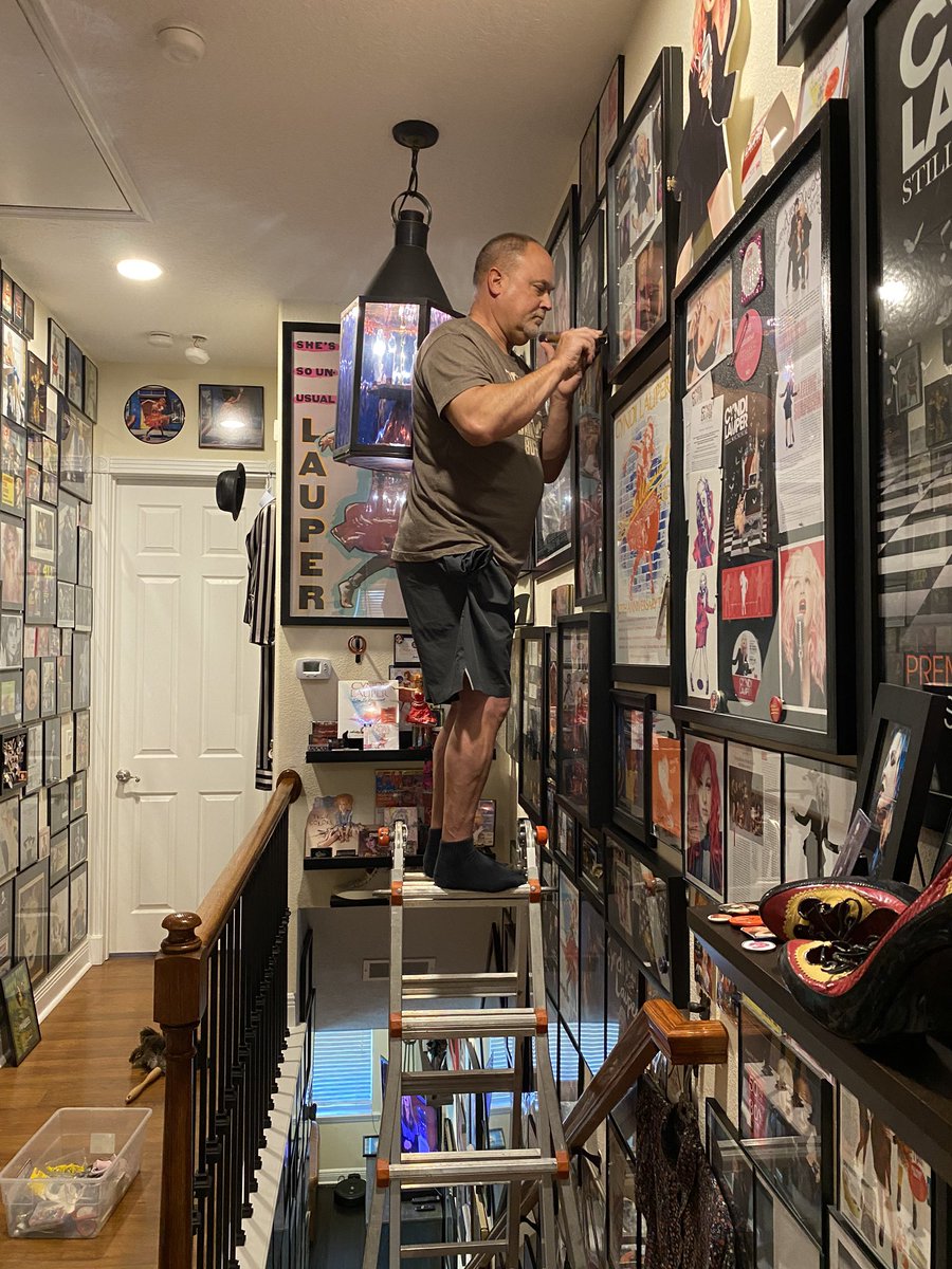 CyndiMuseum's tweet photo. This was yesterday... David taking his life in his hands to hang memorabilia 🙏 ... top of the ladder perched ON the stairs. Was it worth it? YES!! #relationshipgoals #daredevil #ballsy #deathdefying #cyndilauper @cyndilauper #ladderworkout #deathwish @CyndiTeam https://t.co/O0oTu2odDU