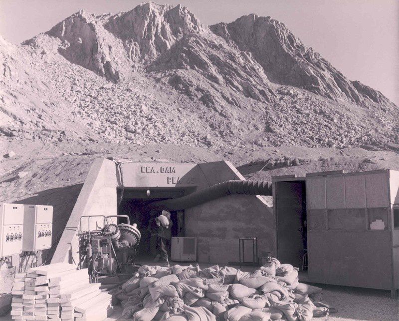 Pour fermer la galerie, des doubles portes blindées sont mises en place et scellées dans le granit. Une multitude de sacs remplis de sable renforce l’étanchéité des portes blindées. L’ensemble de la galerie est bouché une fois la bombe introduite.