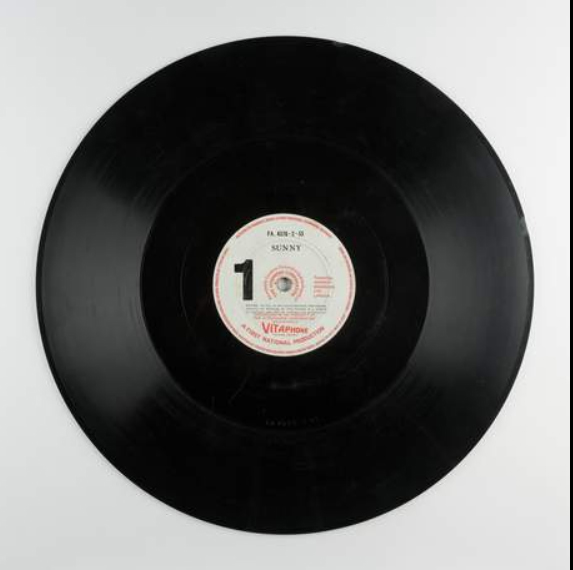 Here’s a Vitaphone disc from the 1930 musical, Sunny. It’s 40.5cm diameter and each side contains around 11 minutes of music – the same length as a reel of film. Sunny had 9 reels and 9 sides to contain the dialogue and the sparkling Jerome Kern and Oscar Hammerstein score.