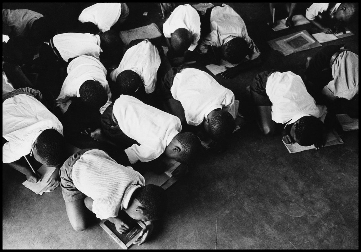 'Students kneel on floor to write. Government have no desire to furnish schools for blacks'© Ernest Cole