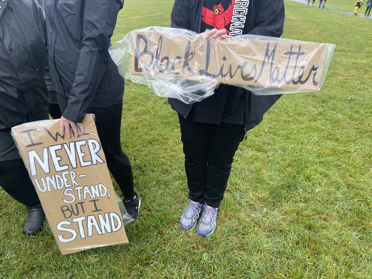 signs in clear plastic bags for a rainy rally for black lives