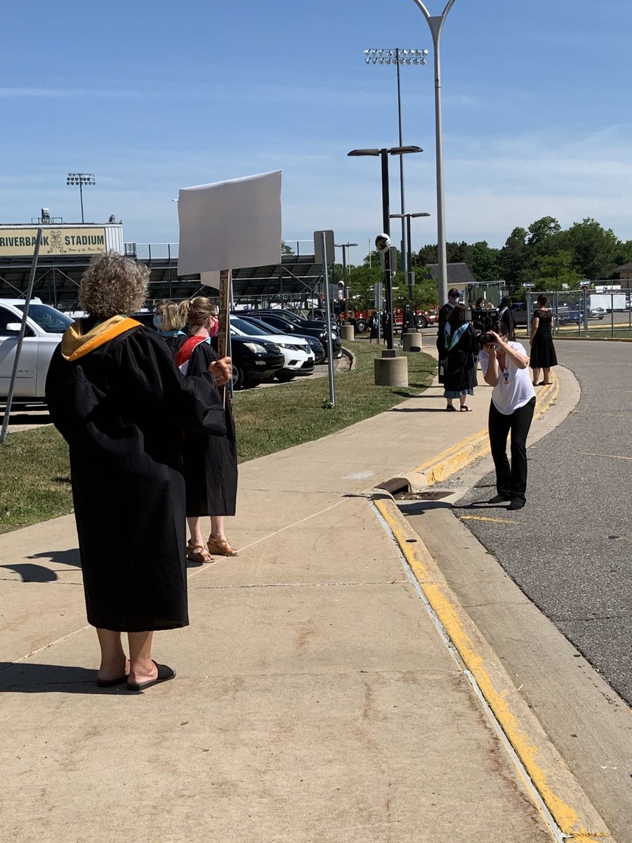 Huron Staff line the sidewalks cheering graduates on.