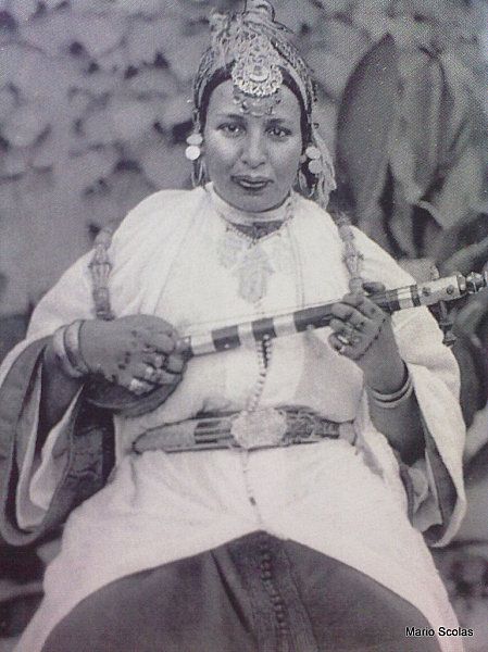 Elle était analphabète et issue d’une famille modeste mais savait très bien manier la langue. Grâce à son talent, elle devient une « cheikha » (chanteuse populaire libre et engegée pour chanter lors d’événements). Très tôt, elle dénonce les dérives des caïds et chef de tribus.