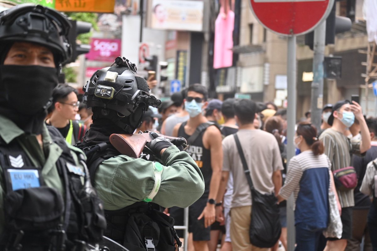 A slightly irate anti riot officer loaded his weapon and threatened to fire it at the crowd yards away due to…loud chanting.