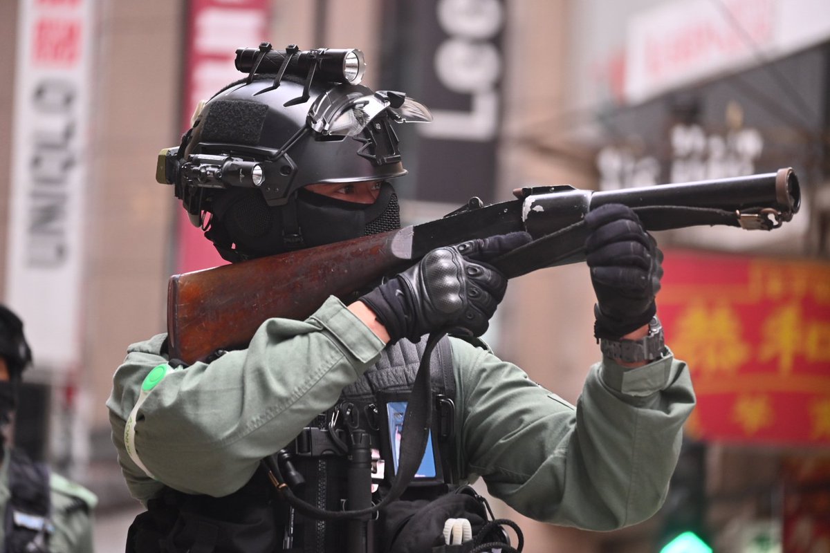A slightly irate anti riot officer loaded his weapon and threatened to fire it at the crowd yards away due to…loud chanting.